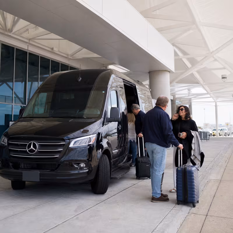 Group boarding a white charter bus for Airport Transportation transportation in Arlington