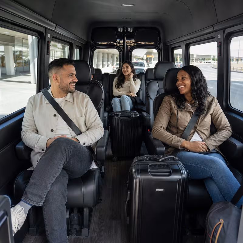 Passengers loading luggage while boarding an Arlington group shuttle