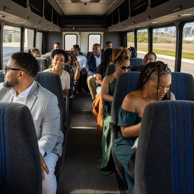 Group boarding a white charter bus for Private Event Transportation transportation in Arlington