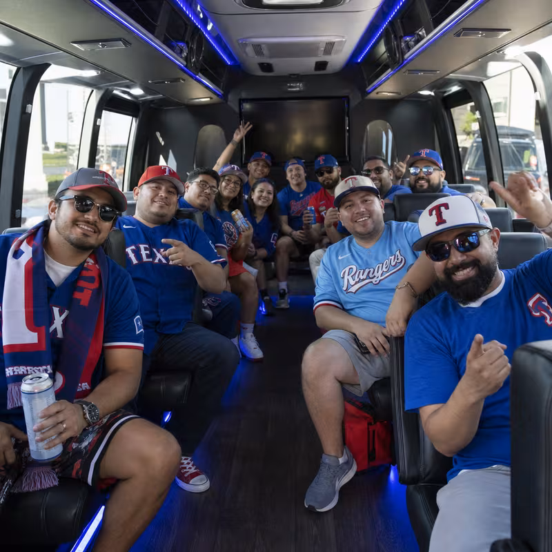 Group boarding a white charter bus for Sporting Event Transportation transportation in Arlington