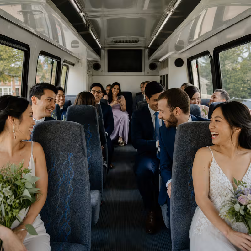 Group boarding a white charter bus for Wedding Transportation transportation in Arlington